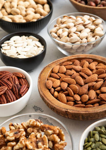 istock Mixed raw nuts and seeds in bowls on kitchen table.Peanut,hazelnut,walnut,almonds,pistachio,sunflower,pumpkin,chia and cashew.Macro 2170130524
