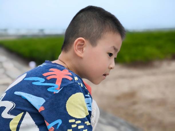 istock A little boy squatted on the ground and played 2170130664