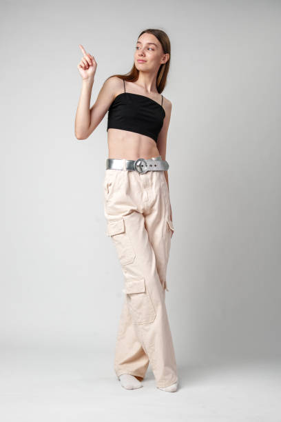 istock Young Woman Pointing to copy space in studio 2170130917