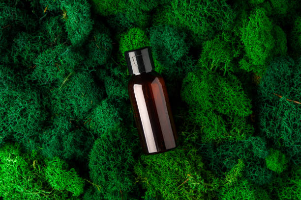 istock Brown glass bottle resting on lush green moss in a natural setting 2170131182