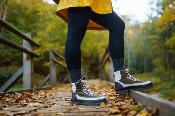 istock A hiker walks along a leaf-covered path in a vibrant autumn forest wearing a bright yellow raincoat and sturdy boots. 2170131217