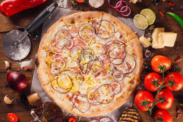 istock Delicious pizza lying on wooden table surrounded by fresh ingredients 2170131514
