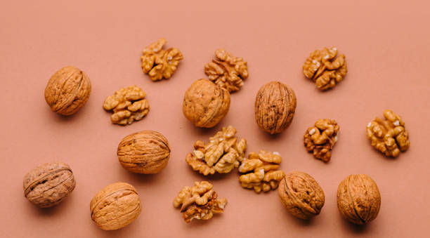 istock Walnuts in shell and peeled are lying on a brown background 2170131666