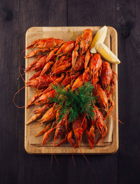 Plate with boiled crayfishes on rustic wooden table