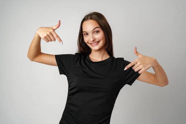 istock Young Woman Pointing to Copy Space Against a Light Background 2170132345