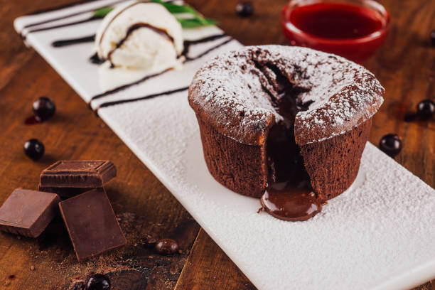 Delicious chocolate lava cake oozing on white plate with ice cream