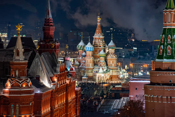 вид сверху на собор василия блаженного в москве ночью, с его яркими подсвеченными куполами, в окружении исторических зданий и кремлевских б - кремль стоковые фото и изображения