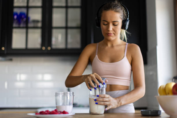 istock Sportswoman preparing smoothie in her kitchen 2170135365