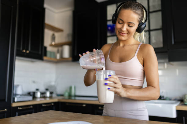 istock Sportswoman preparing smoothie in her kitchen 2170135443