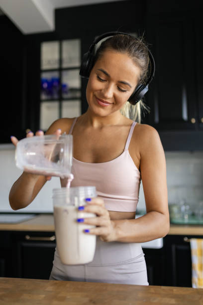 istock Sportswoman preparing smoothie in her kitchen 2170135444