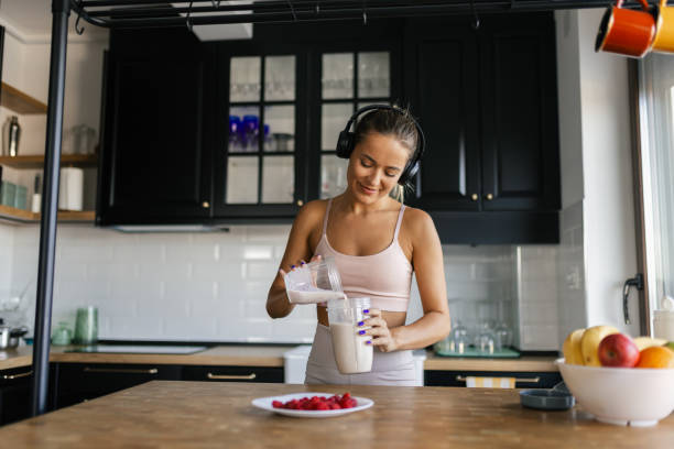 istock Sportswoman preparing smoothie in her kitchen 2170135450