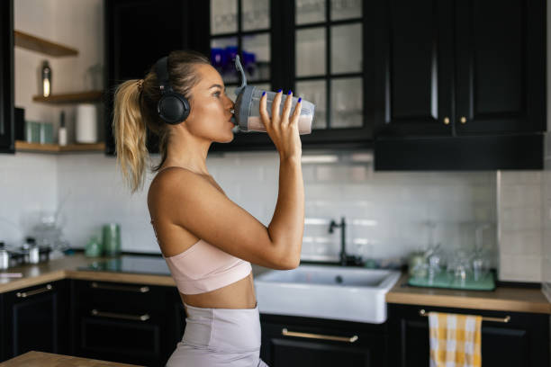 Sportswoman drinking smoothie in the kitchen