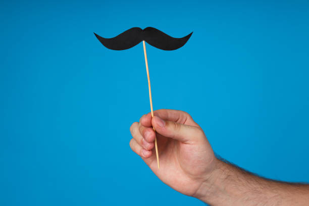 istock Black, paper mustache in a man's hand 2170136096