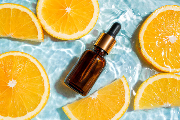 Retinol serum bottle and oranges in water