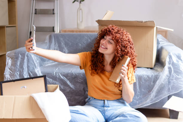 istock Cheerful woman taking selfie while moving into new apartment 2170141533