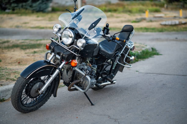 istock An old motorcycle is parked by the road. 2170142651