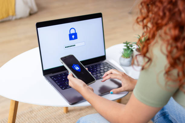istock Woman using two-factor authentication on laptop and smartphone at home 2170143889