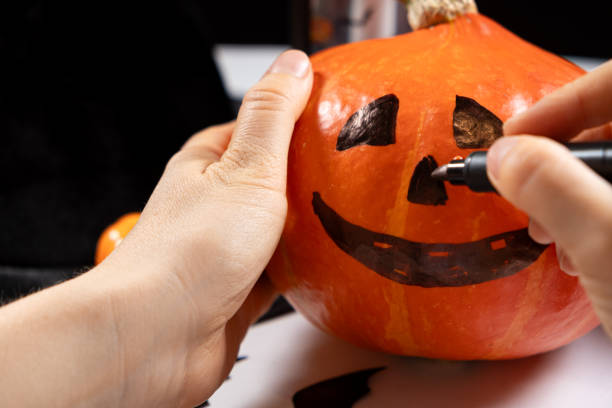 istock Creating a Hokkaido pumpkin jack-o'-lantern for Halloween. 2170144829