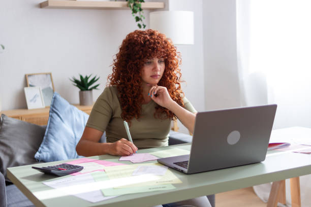 istock Focused freelancer managing finances and working on laptop at home office 2170145086