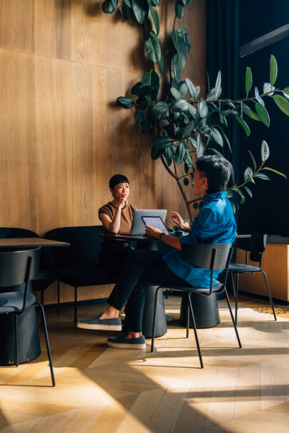 istock Colleagues Engaged in Productive Discussion in Modern Cafe Setting 2170146463