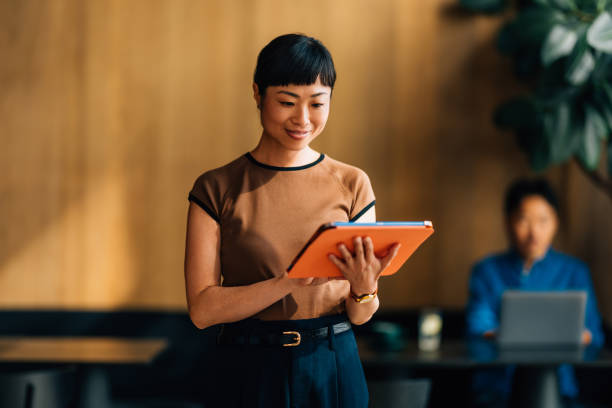 Asian Businesswoman Using Digital Tablet in Modern Office Space