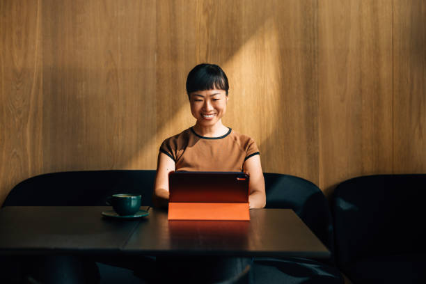 istock Young Woman Enjoying Coffee and Working on a Tablet 2170146487