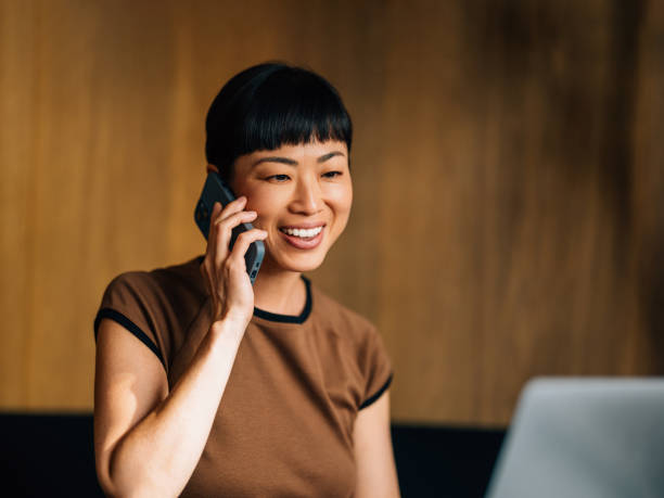 Smiling Woman Talking on Phone in Modern Office Setting