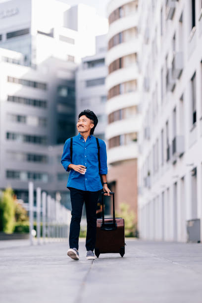 istock Confident Traveler Walking in Modern Urban Setting With Luggage 2170146517