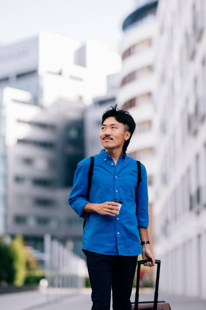istock Confident Businessman Walking With Coffee and Suitcase in Urban Setting 2170146538