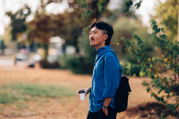Young Asian Man Enjoying Autumn Day in a Peaceful Park Setting