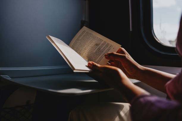 istock Person Reading a Book by the Window on a Train Journey 2170146645