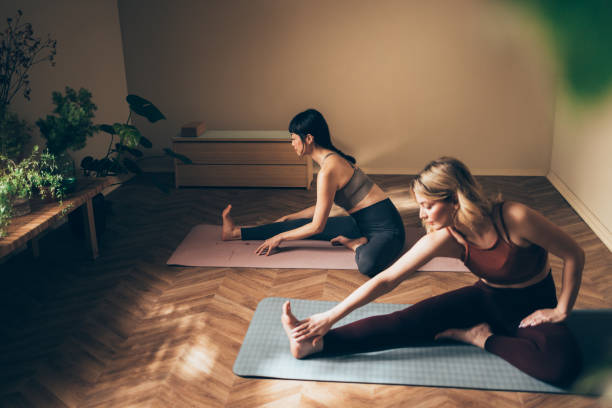 istock Women Practicing Yoga Together in Peaceful Home Setting 2170148010