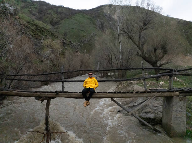 Man sitting on wooden bridge