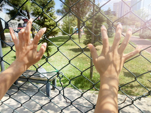 Hand of prisoner in jail as background