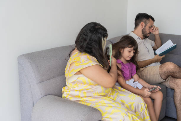 istock Mother Combing Daughter's Hair While Father Reads 2170150512