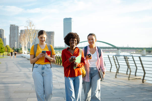 istock Three young women walking outdoors using smartphones and smiling 2170151839