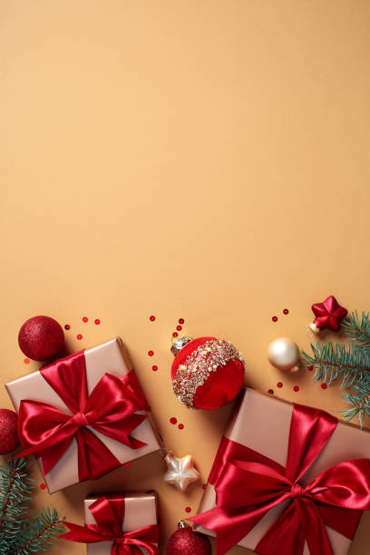 istock Christmas vertical flat lay composition with luxury gift boxes, red balls, fir branches, confetti on beige background. 2170153924