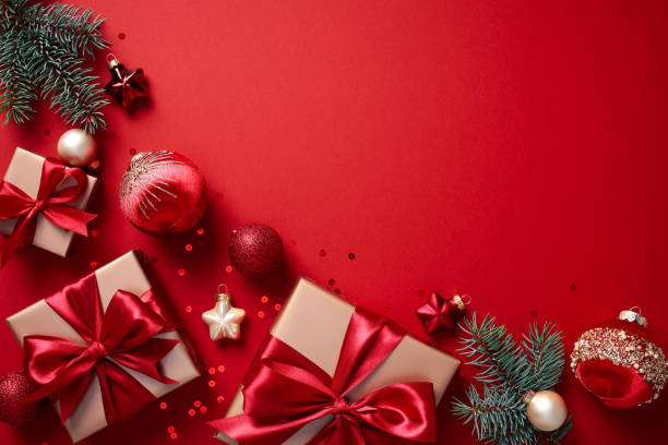 istock Christmas flat lay composition with gifts, ornaments, and pine branches on a red background. Perfect for holiday marketing, seasonal designs, and festive promotion 2170154510