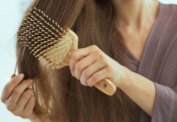 istock Closeup on young woman combing hair 2170156309