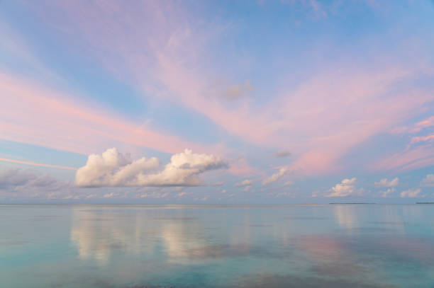 A spectacular sunset in the Maldives. Clouds drift across the horizon whilst the sky beyond lights up with spectacular colours.