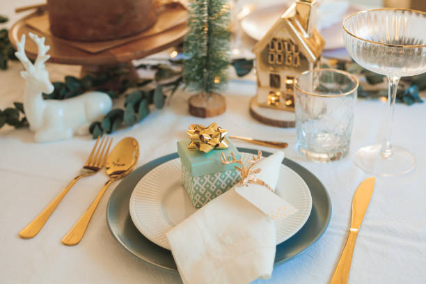 Stylish light Christmas table setting with golden cutlery. Festive feasts. Decorations on the New Year's table.