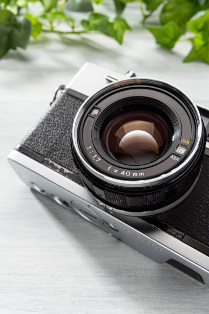 istock Old film camera isolated on wooden table 2170170355