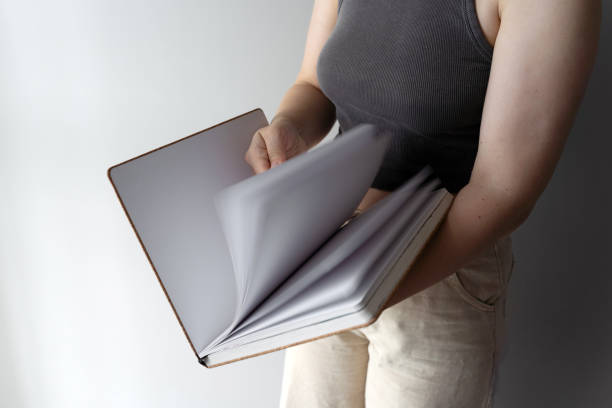 istock Woman flipping through sketchbook pages casually 2170177521