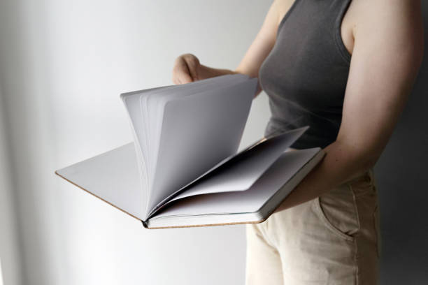 istock Woman flipping through sketchbook pages casually 2170177531