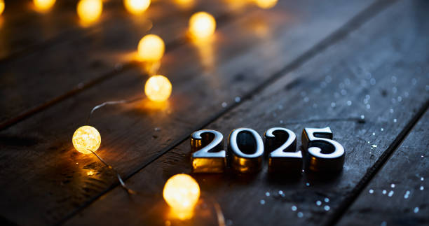 istock Metallic 2025 Numbers on a Rustic Wooden Table with Glowing String Lights for New Year Celebration 2170181059