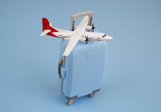 istock Airplane model on blue travel suitcase on blue background. 2170184213