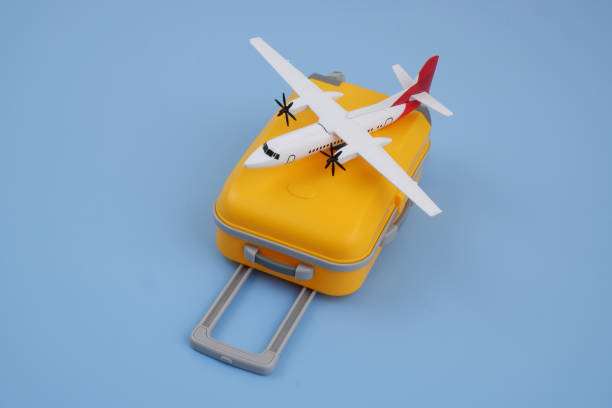 istock Airplane model on orange travel suitcase on blue background. 2170184217