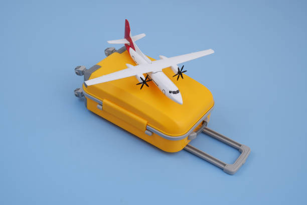 istock Airplane model on orange travel suitcase on blue background. 2170184224