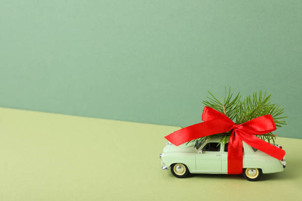 istock A green car with a Christmas tree and a red bow. 2170186765
