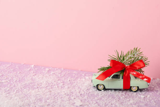 istock A green car with a Christmas tree and a red bow. 2170186790